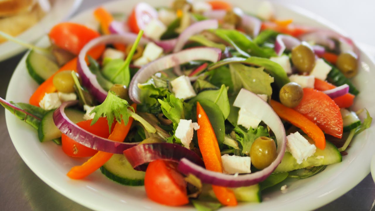 contact-img-02 A vibrant Mediterranean salad featuring fresh vegetables, olives, and feta cheese for a healthy meal.